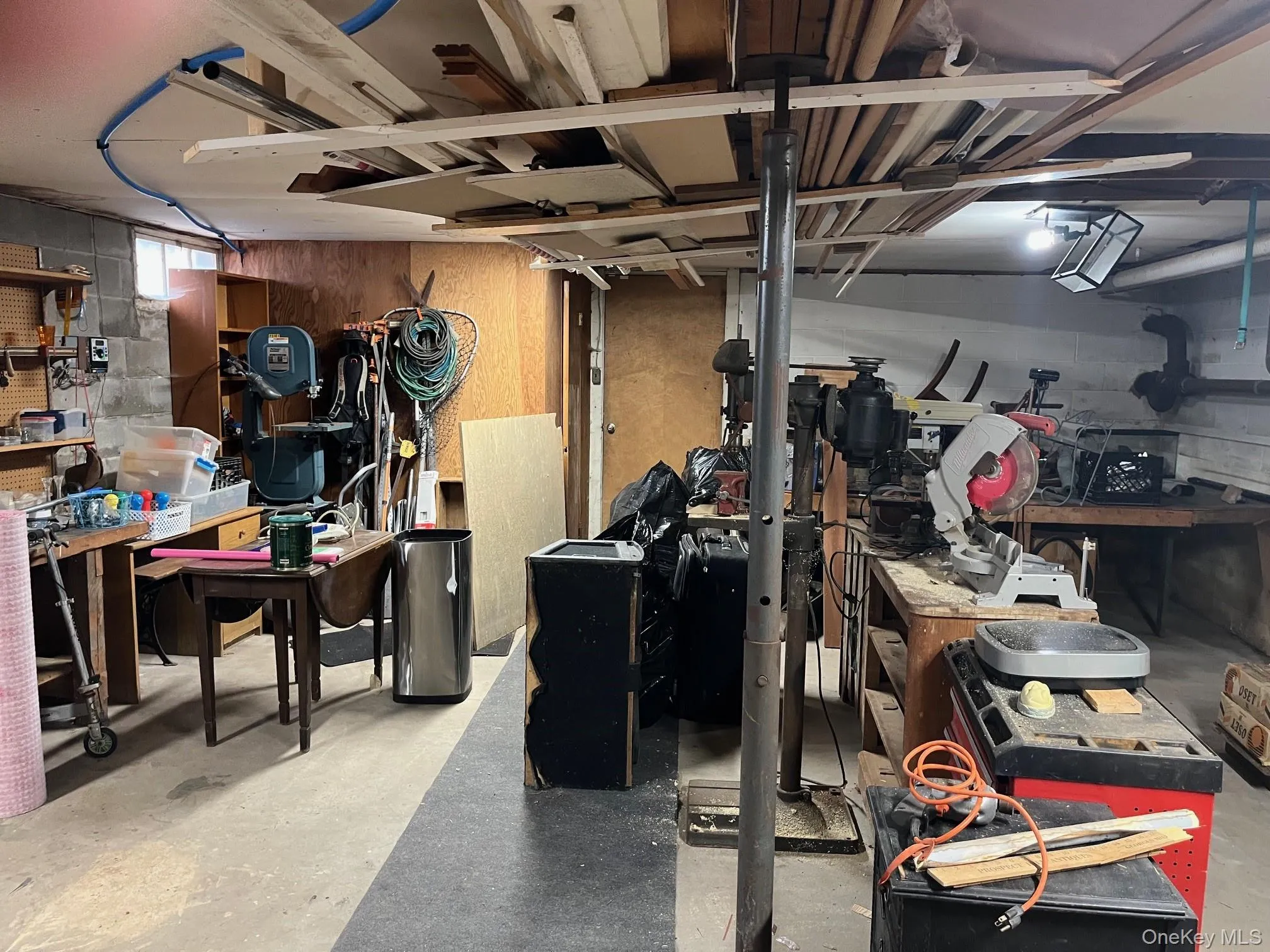 Below grade area featuring a workshop area and concrete block wall Below grade area featuring a workshop area and concrete block wall