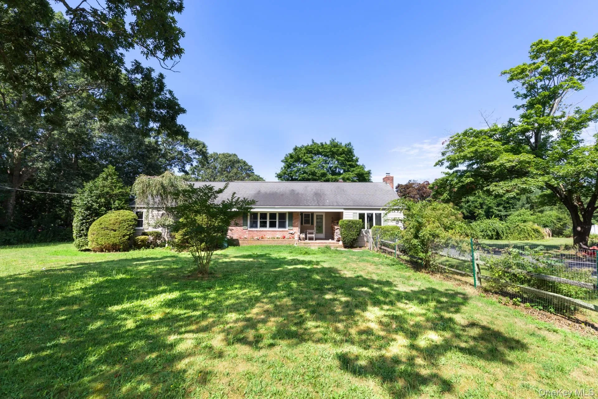 Single story home featuring brick siding, a patio area, and a chimney Single story home featuring brick siding, a patio area, and a chimney
