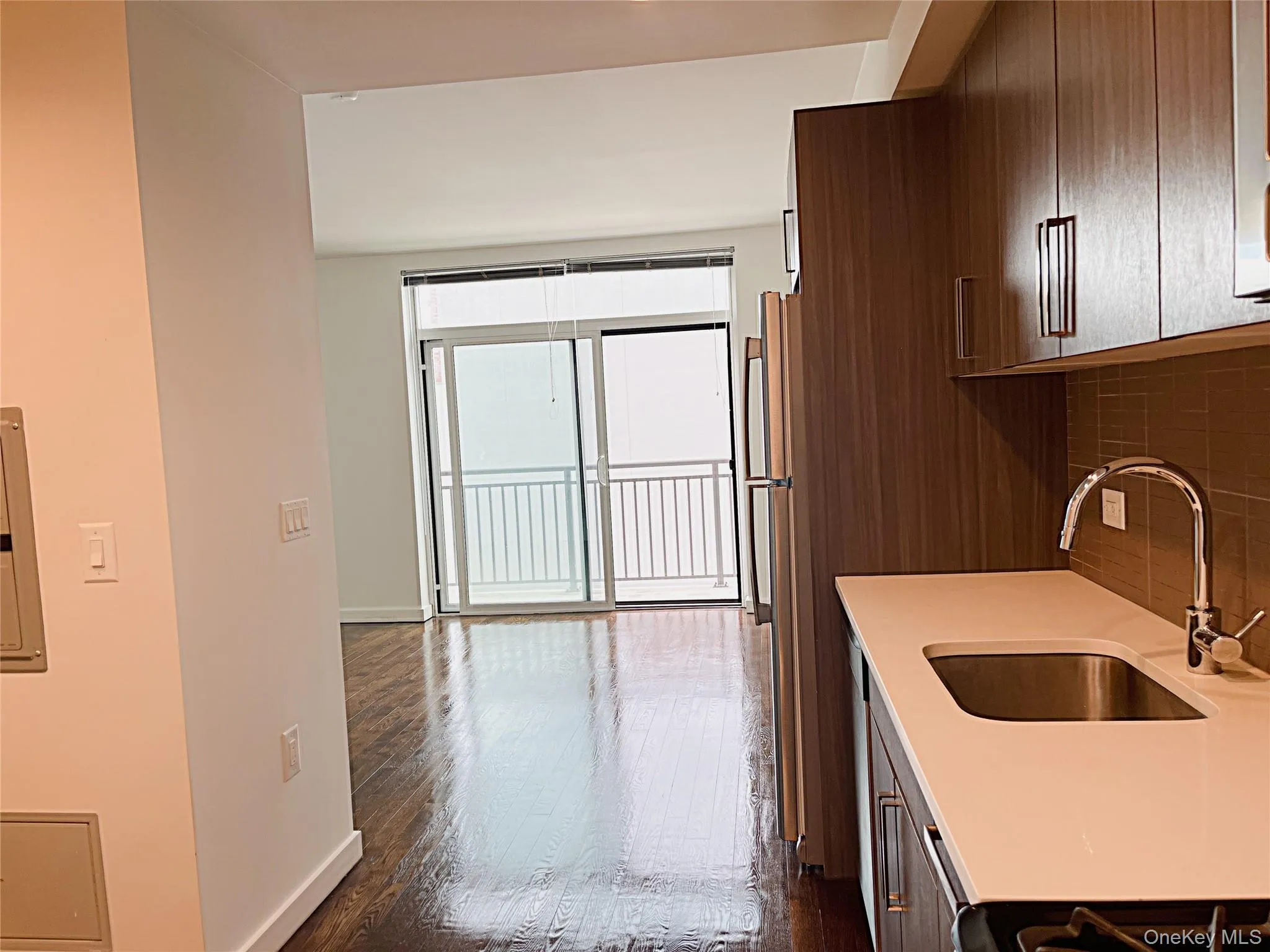 Kitchen with dark wood finished floors, decorative backsplash, electric panel, modern cabinets, and light stone countertops Kitchen with dark wood finished floors, decorative backsplash, electric panel, modern cabinets, and light stone countertops