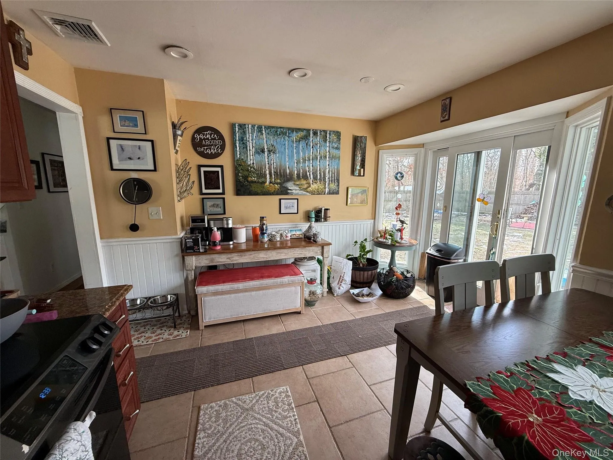 Dining room featuring a wainscoted wall, light tile patterned flooring, and recessed lighting Dining room featuring a wainscoted wall, light tile patterned flooring, and recessed lighting