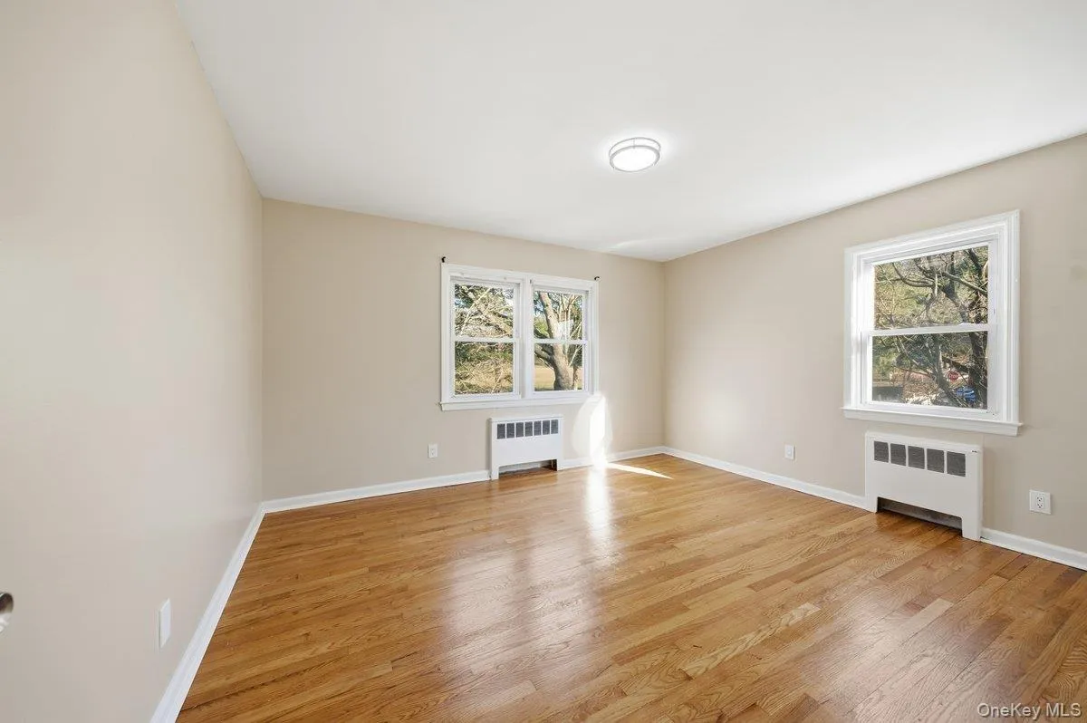 Unfurnished room with radiator and light wood-style floors Unfurnished room with radiator and light wood-style floors