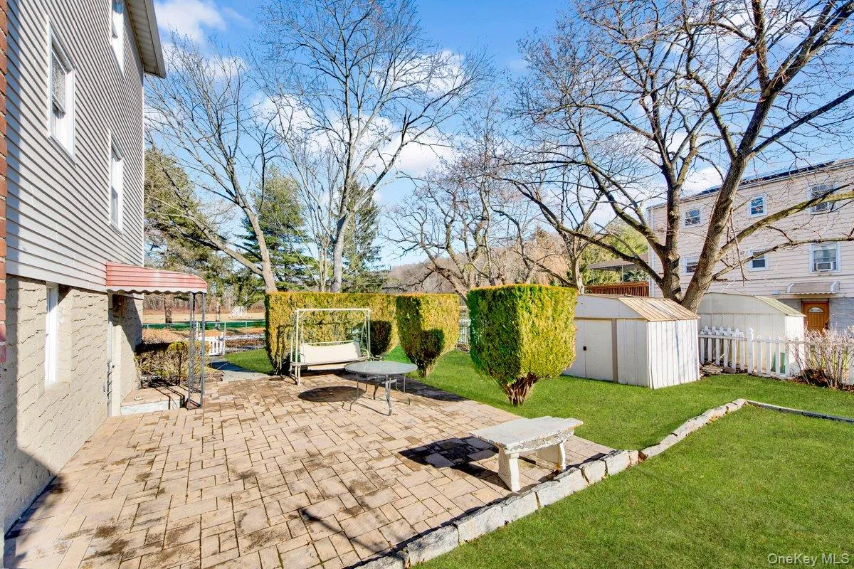 Fenced backyard with a patio area and a storage unit Fenced backyard with a patio area and a storage unit