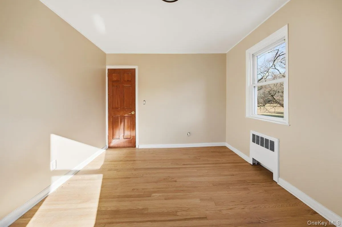 Unfurnished room Bedroom with radiator and light wood-type flooring Unfurnished room Bedroom with radiator and light wood-type flooring