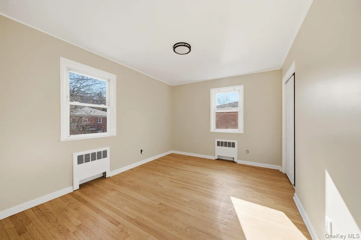 Spare room featuring radiator heating unit and light wood-style flooring Spare room featuring radiator heating unit and light wood-style flooring