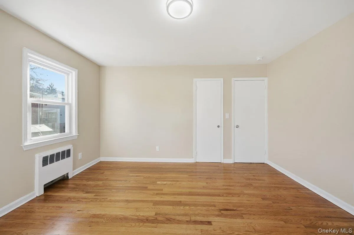Bedroom with radiator and light wood-type flooring Bedroom with radiator and light wood-type flooring