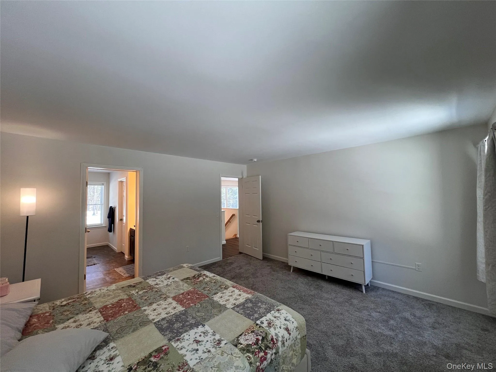 Bedroom with dark carpet and baseboards Bedroom with dark carpet and baseboards
