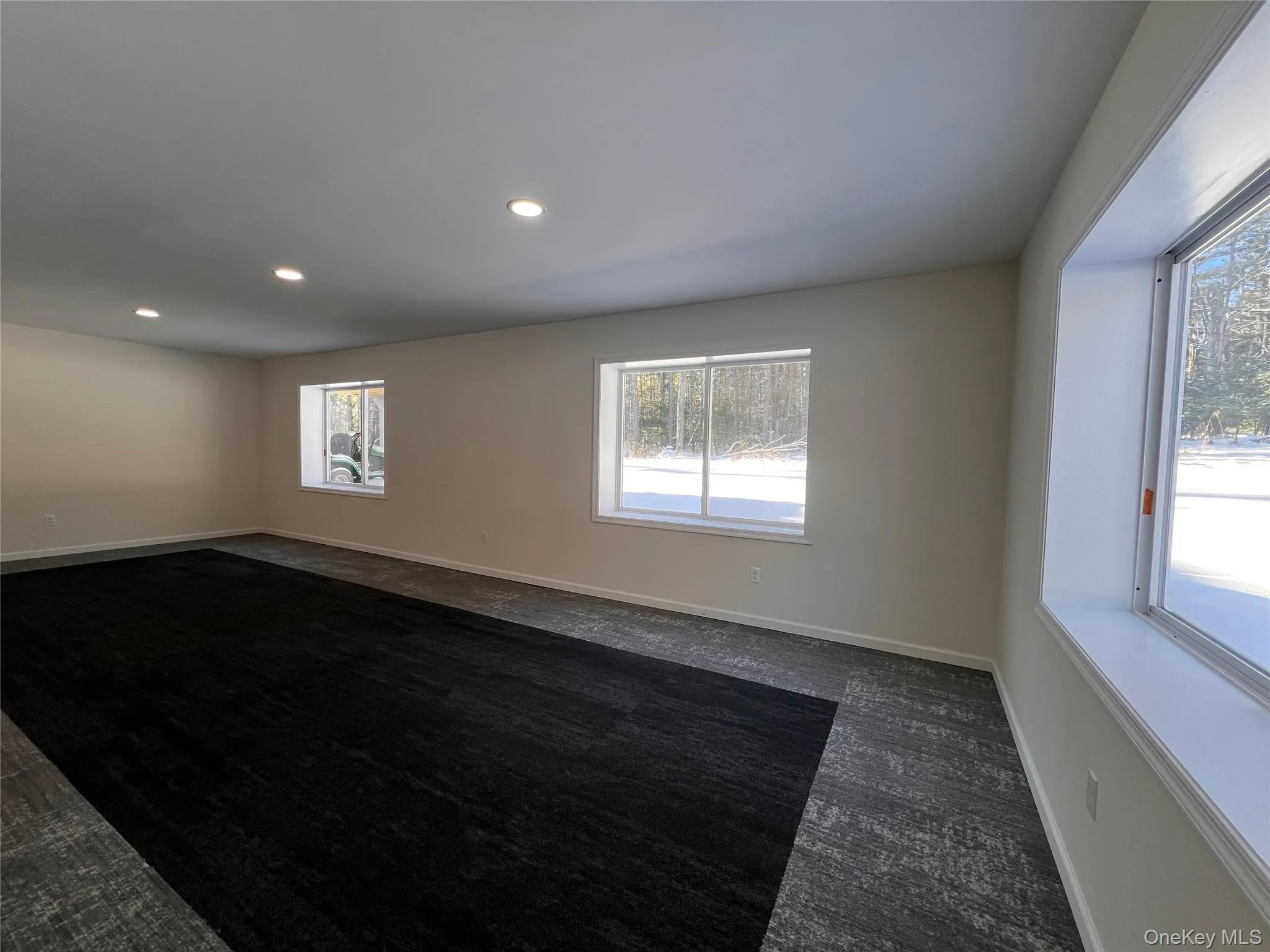Unfurnished room with recessed lighting and dark colored carpet Unfurnished room with recessed lighting and dark colored carpet