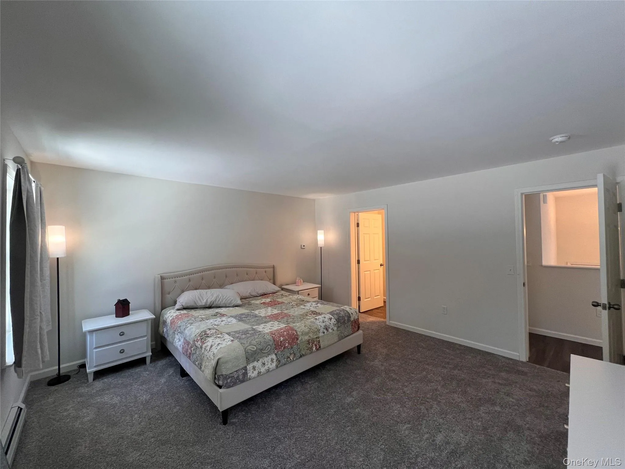 Bedroom with carpet floors and baseboard heating Bedroom with carpet floors and baseboard heating