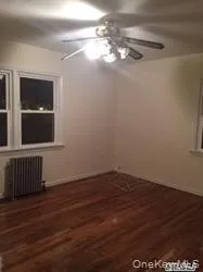 Spare room with radiator, dark wood finished floors, and ceiling fan Spare room with radiator, dark wood finished floors, and ceiling fan