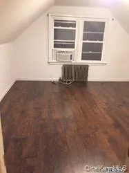 Bonus room featuring lofted ceiling, dark wood finished floors, radiator, and cooling unit Bonus room featuring lofted ceiling, dark wood finished floors, radiator, and cooling unit