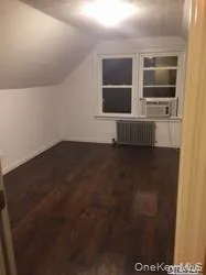 Bonus room featuring lofted ceiling, dark wood-style floors, radiator heating unit, and cooling unit Bonus room featuring lofted ceiling, dark wood-style floors, radiator heating unit, and cooling unit