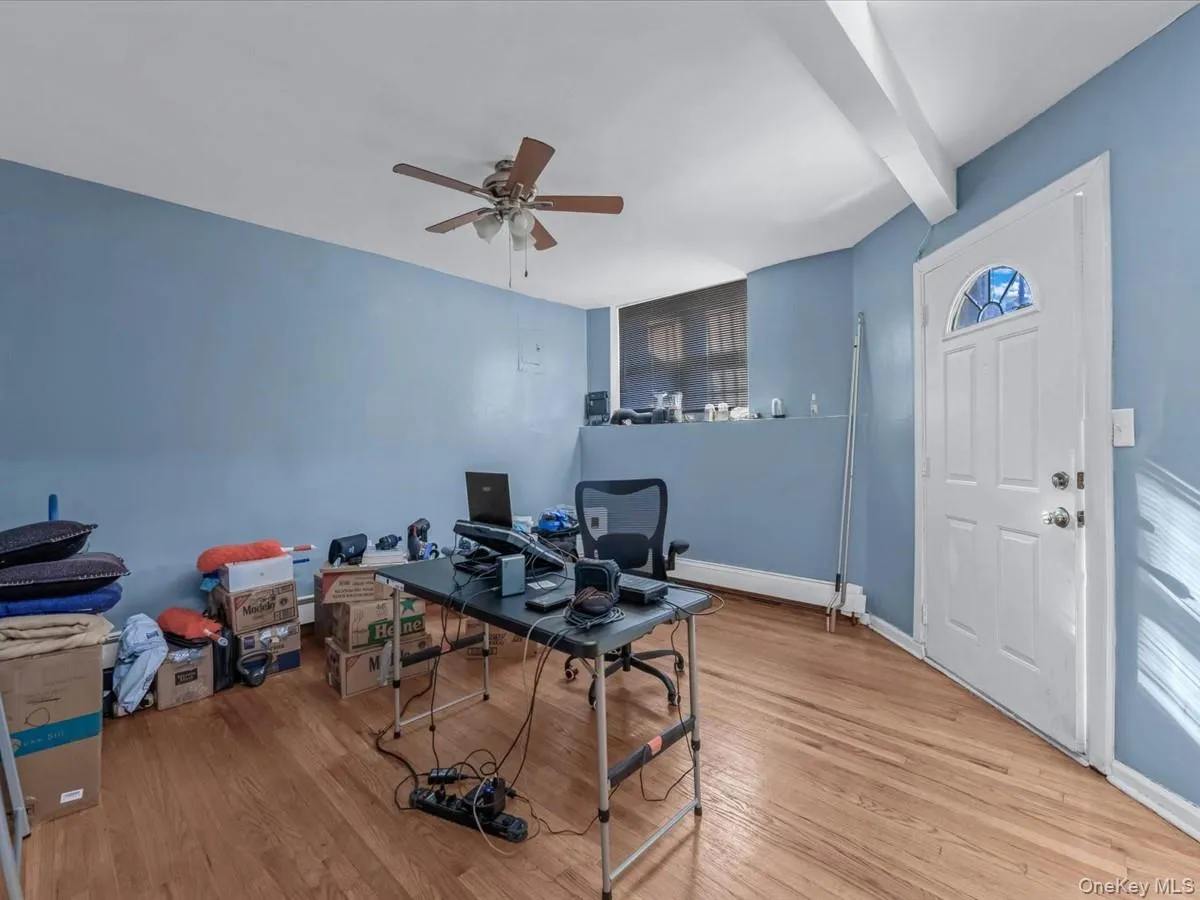 Office space featuring light wood-style flooring, ceiling fan, and beam ceiling Office space featuring light wood-style flooring, ceiling fan, and beam ceiling