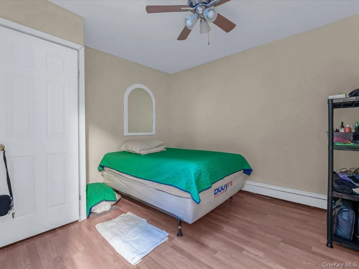 Bedroom with wood finished floors, a baseboard heating unit, and ceiling fan Bedroom with wood finished floors, a baseboard heating unit, and ceiling fan