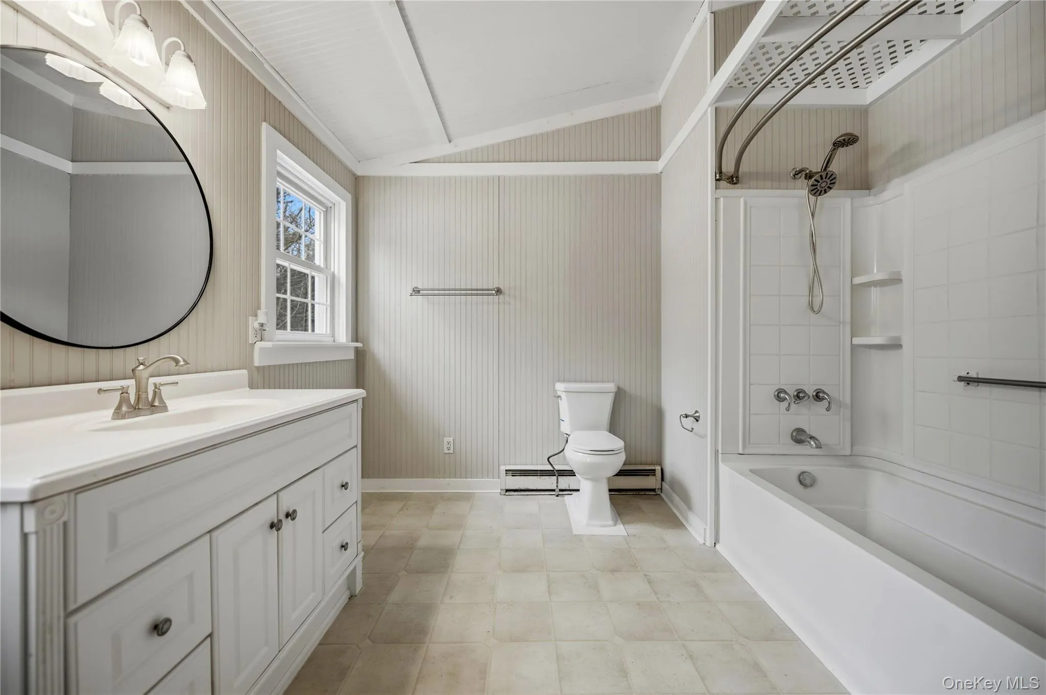 Bathroom with bathtub / shower combination, vanity, lofted ceiling, a baseboard heating unit, and a baseboard radiator Bathroom with bathtub / shower combination, vanity, lofted ceiling, a baseboard heating unit, and a baseboard radiator