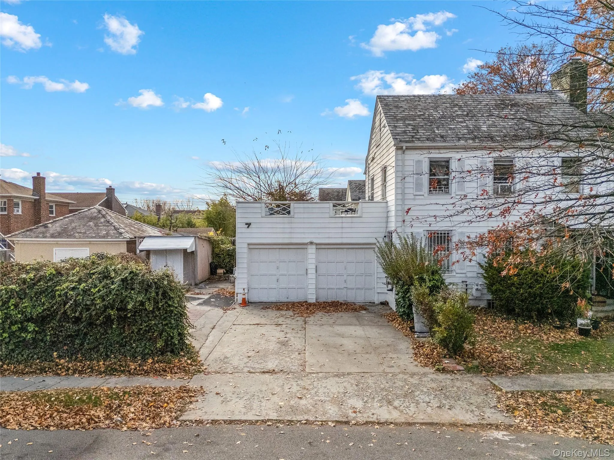 View of side of property with a chimney, concrete driveway, and a garage View of side of property with a chimney, concrete driveway, and a garage