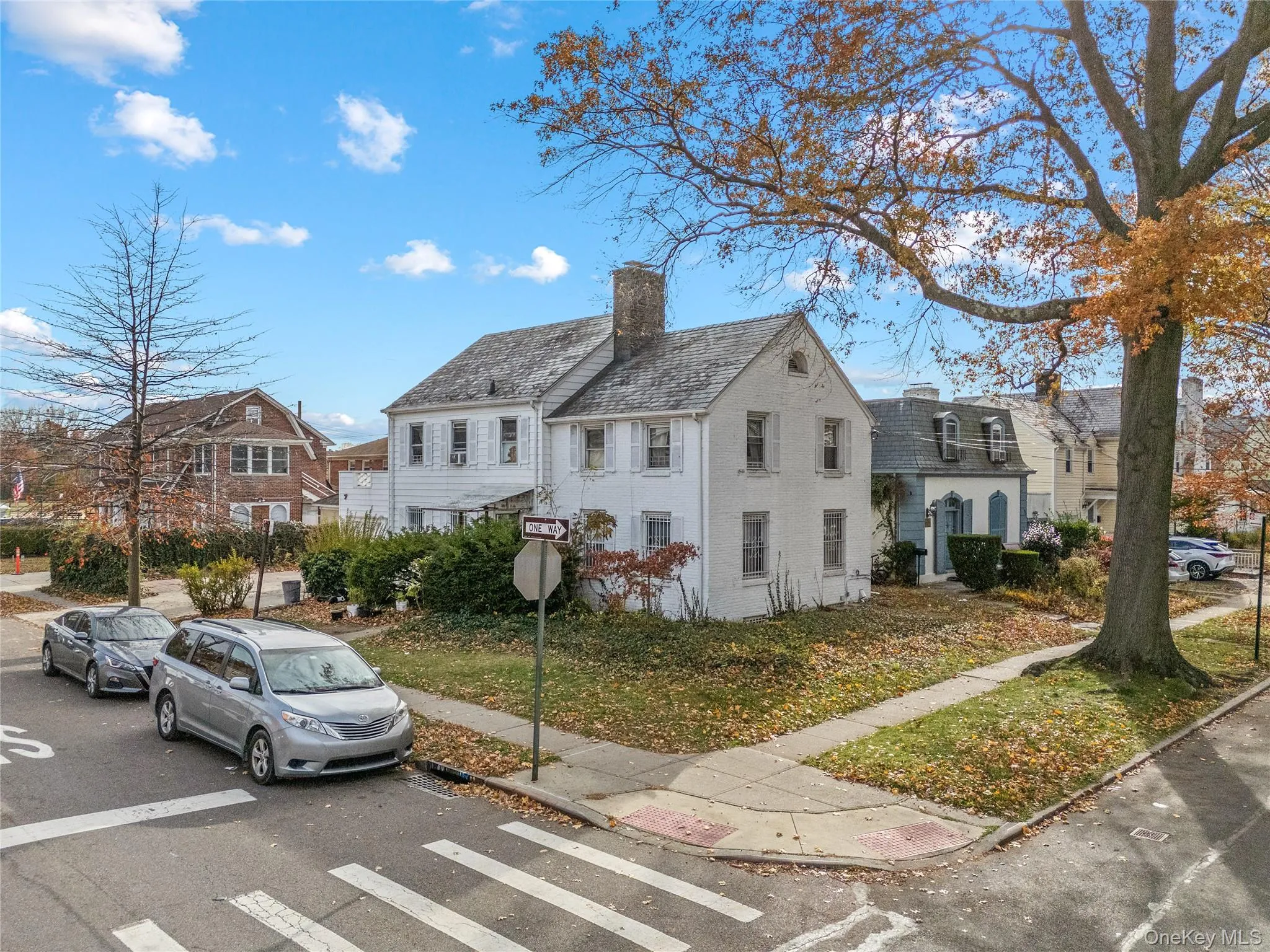 View of front of house with a chimney, a residential view, a high end roof, and uncovered parking View of front of house with a chimney, a residential view, a high end roof, and uncovered parking