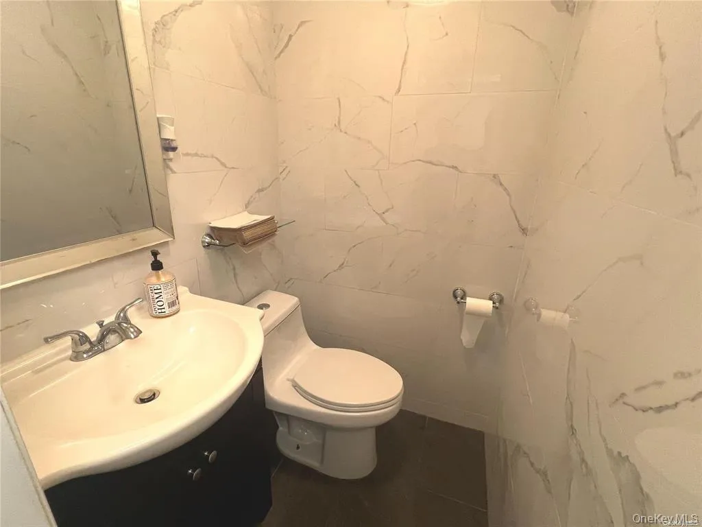 Bathroom featuring tile walls and vanity Bathroom featuring tile walls and vanity
