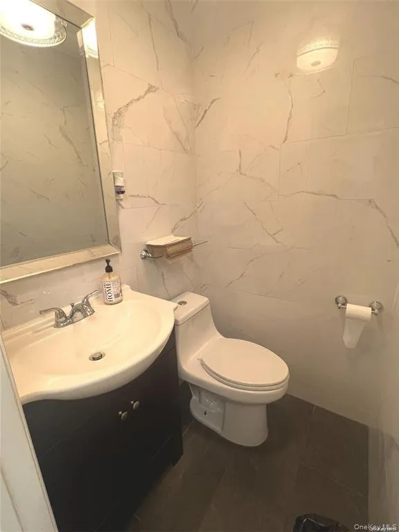 Bathroom featuring tile walls and vanity Bathroom featuring tile walls and vanity