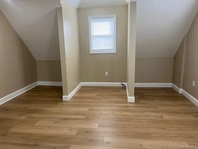 Bonus room featuring vaulted ceiling and light wood-type flooring Bonus room featuring vaulted ceiling and light wood-type flooring