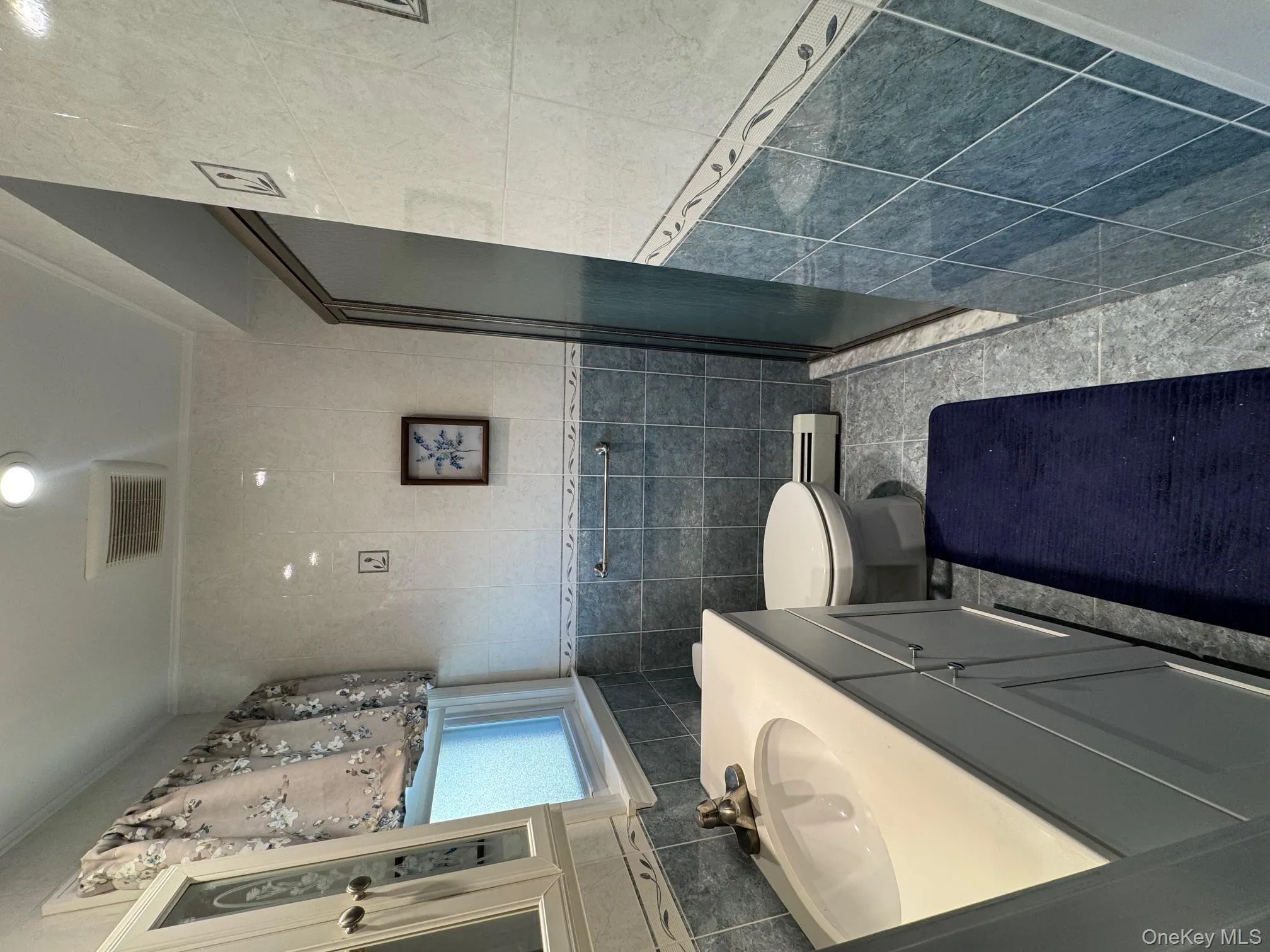 Bathroom featuring a stall shower, vanity, crown molding, tile walls, and light tile patterned flooring Bathroom featuring a stall shower, vanity, crown molding, tile walls, and light tile patterned flooring