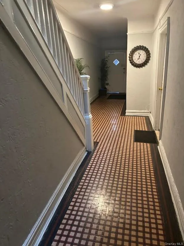 Hall featuring stairs and a textured wall Hall featuring stairs and a textured wall