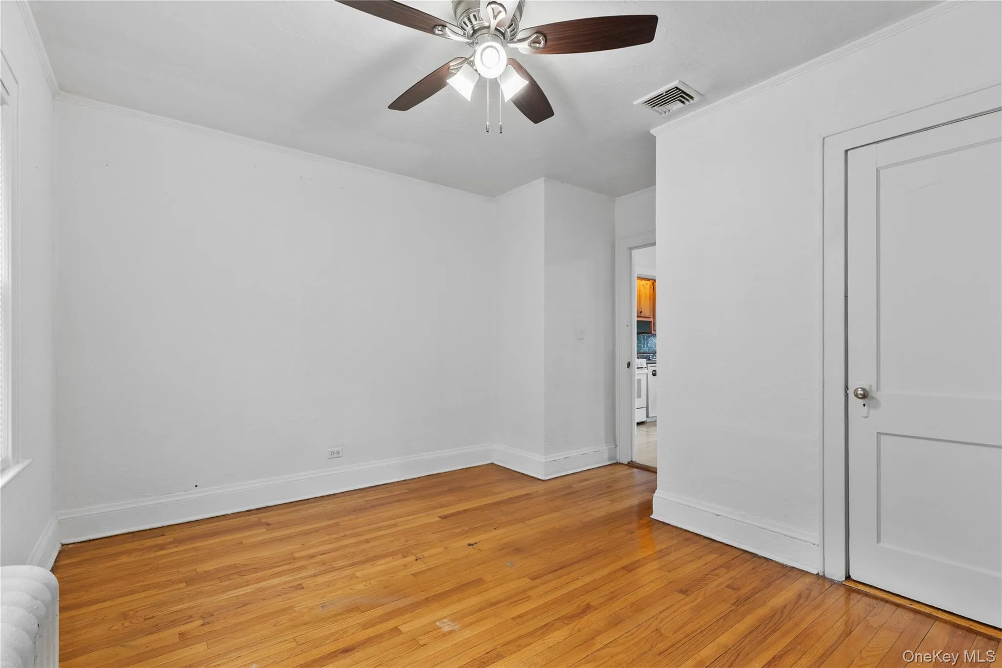 Unfurnished bedroom with light wood-style floors, ceiling fan, and ornamental molding Unfurnished bedroom with light wood-style floors, ceiling fan, and ornamental molding
