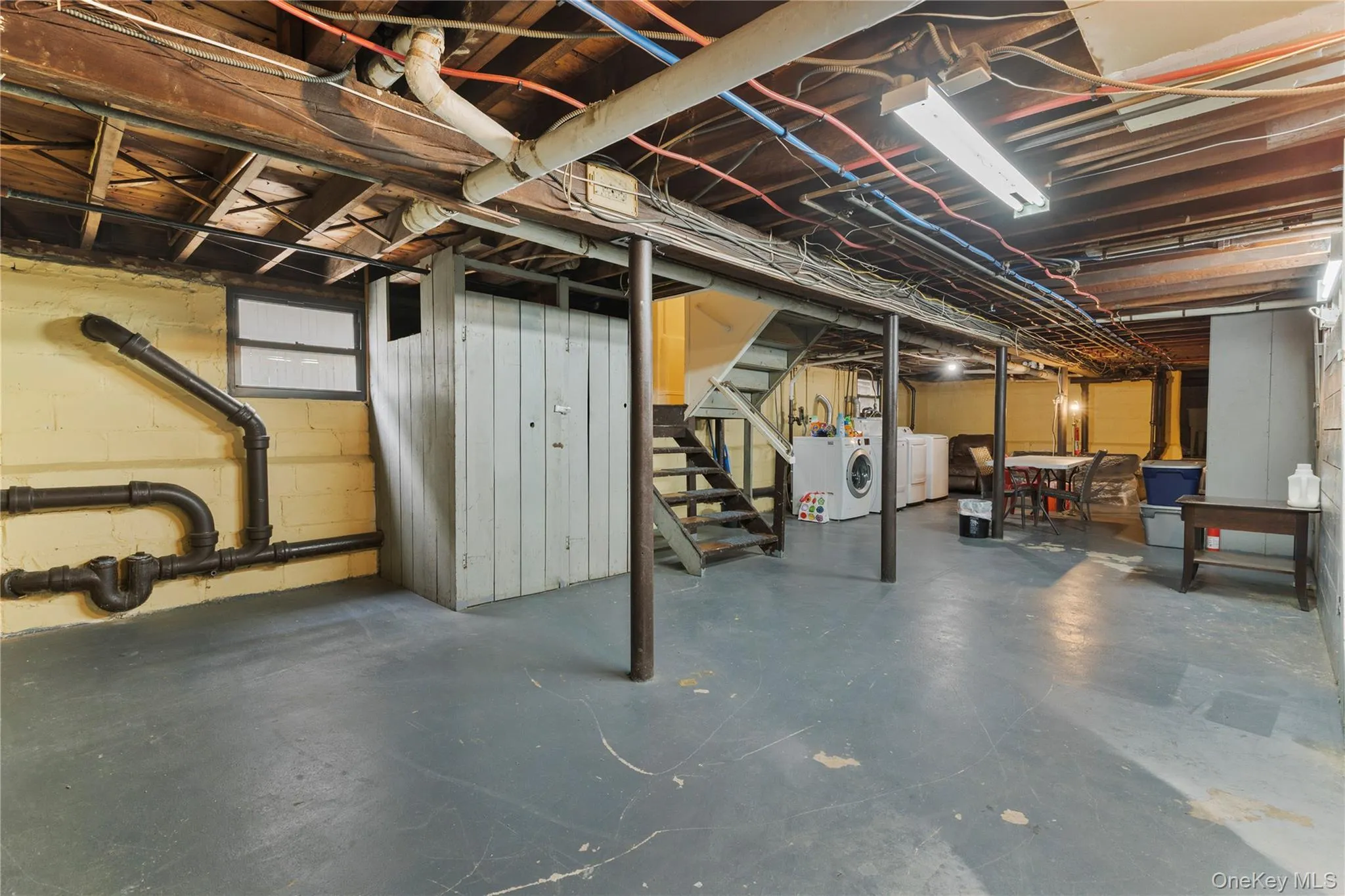 Below grade area featuring stairway and washer and dryer Below grade area featuring stairway and washer and dryer