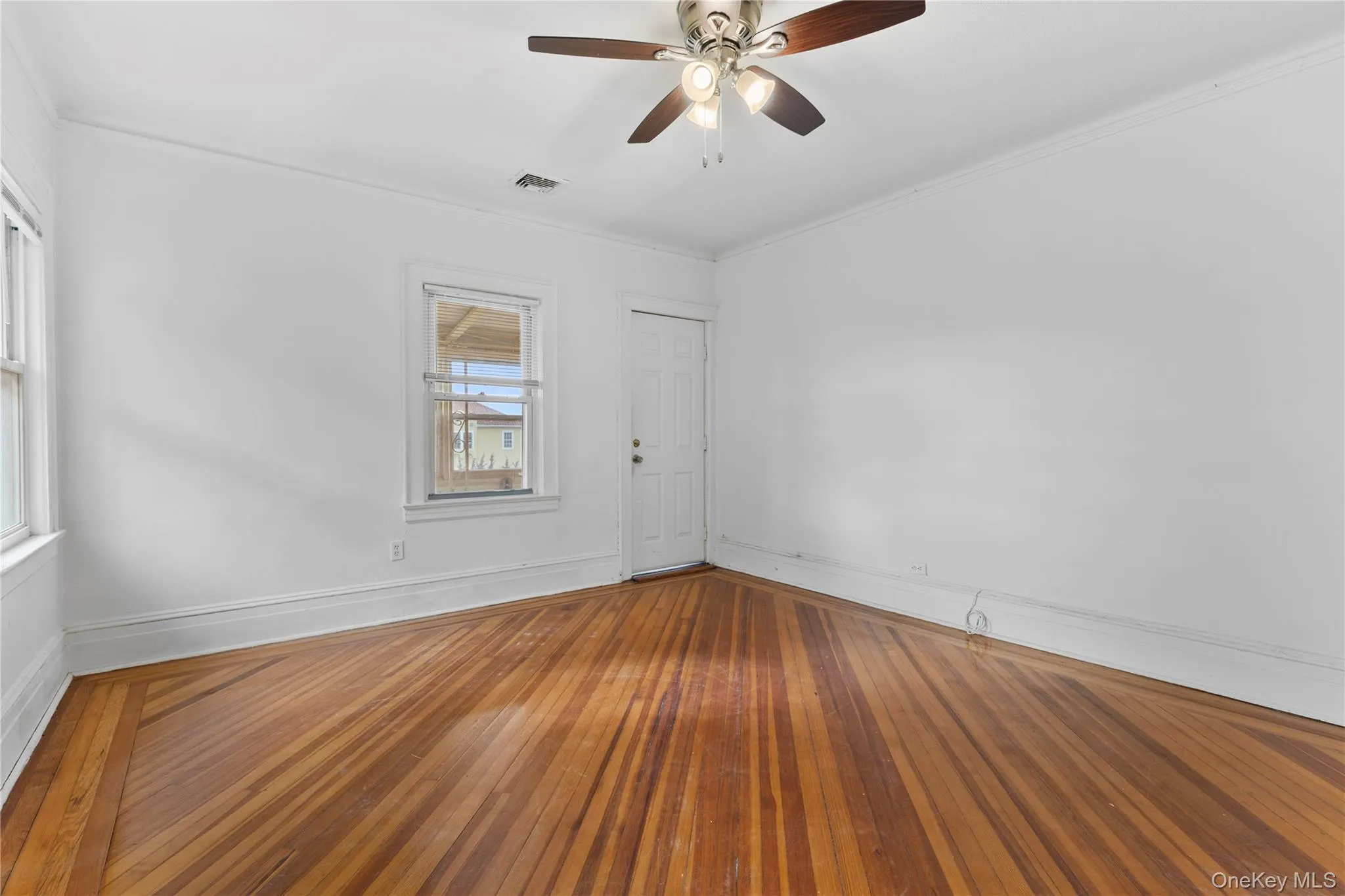 Empty room with hardwood / wood-style floors, crown molding, and ceiling fan Empty room with hardwood / wood-style floors, crown molding, and ceiling fan
