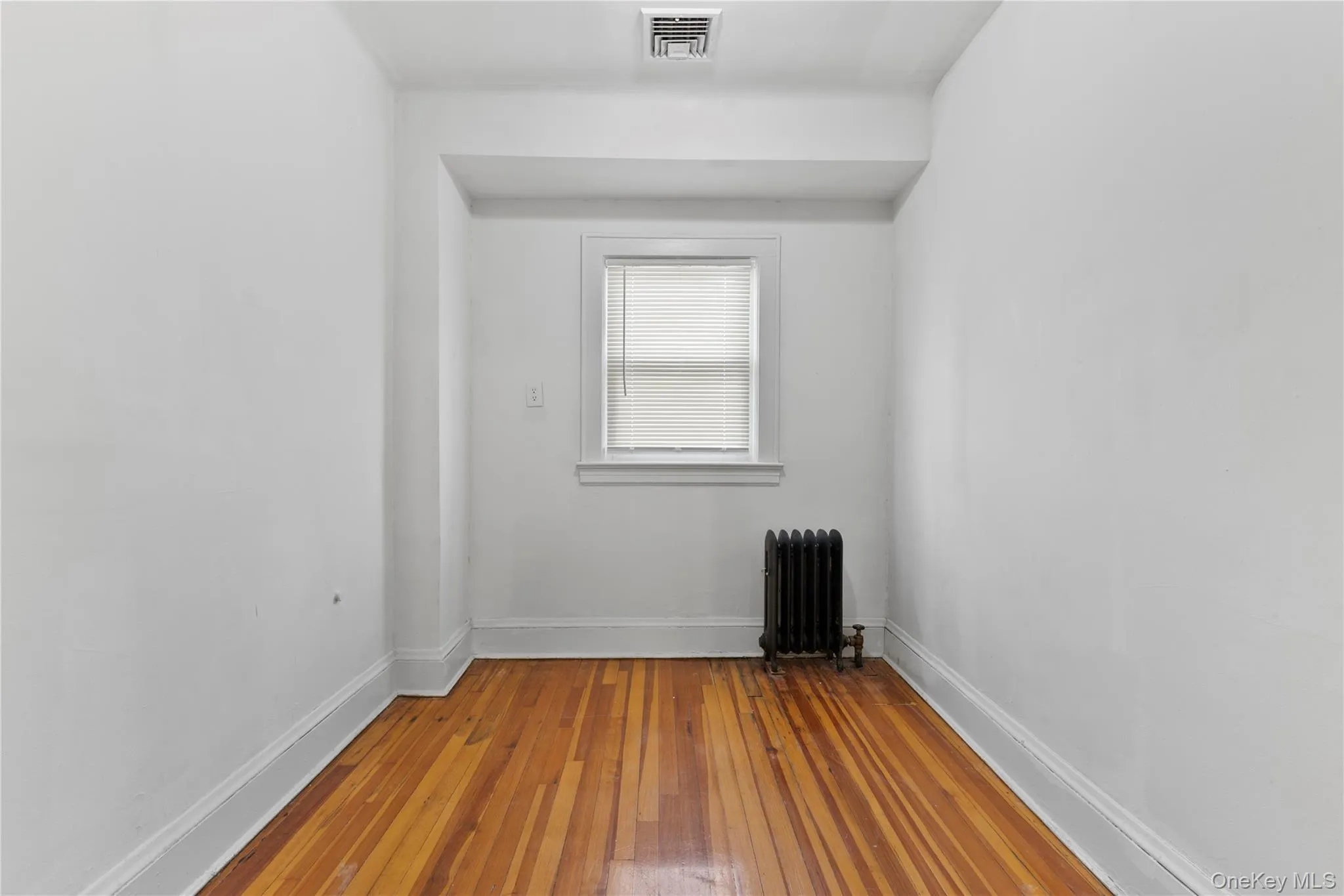 Spare room with light wood-type flooring and radiator heating unit Spare room with light wood-type flooring and radiator heating unit