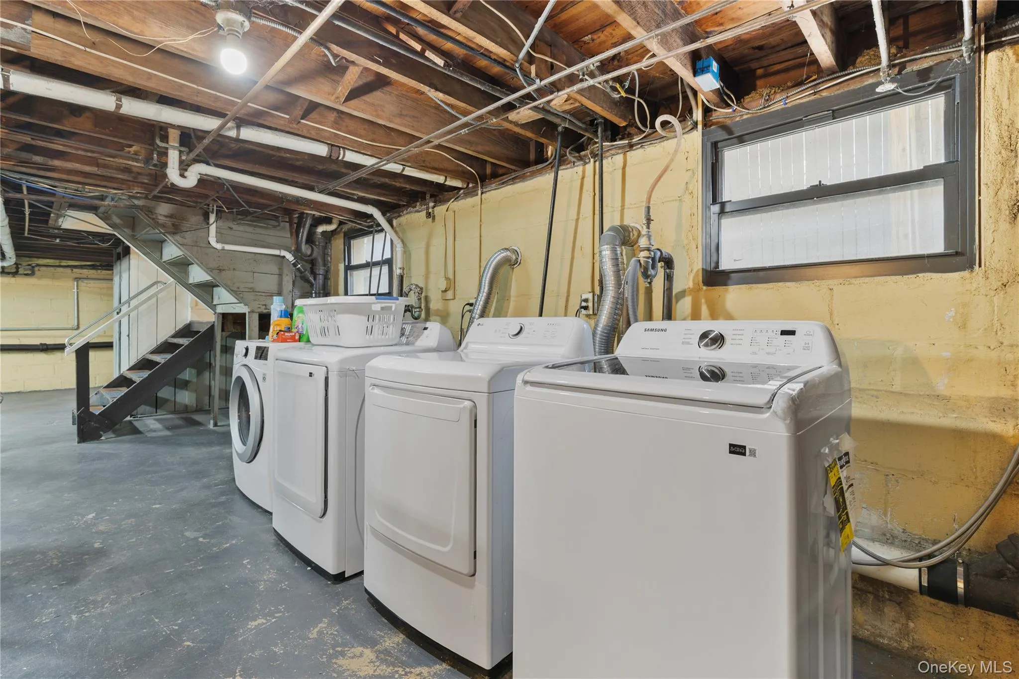 Laundry room with washing machine and clothes dryer and concrete floors Laundry room with washing machine and clothes dryer and concrete floors