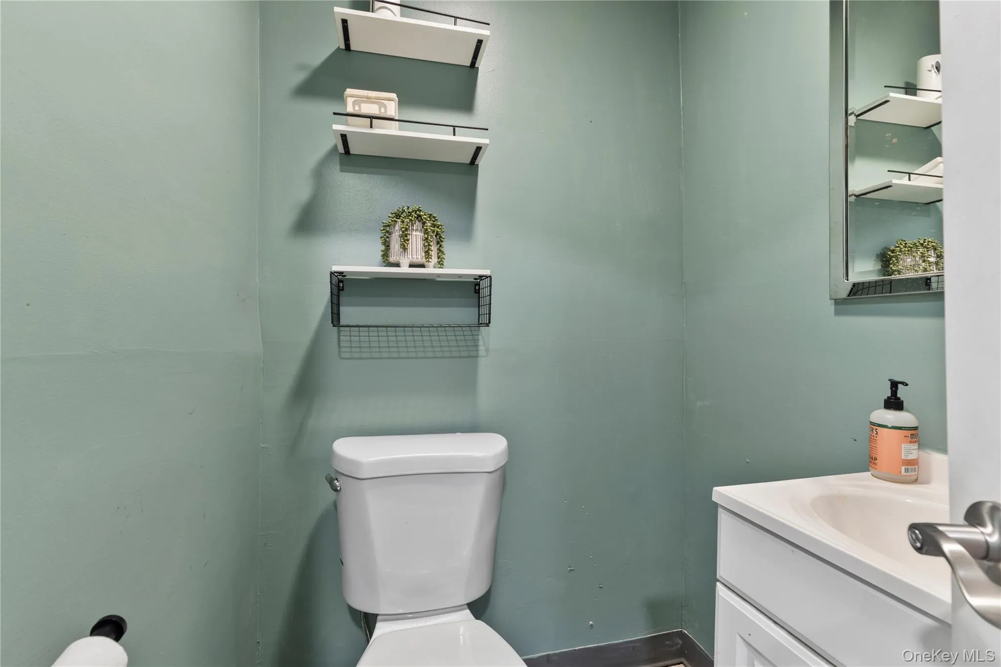 Half bathroom featuring vanity and toilet Half bathroom featuring vanity and toilet