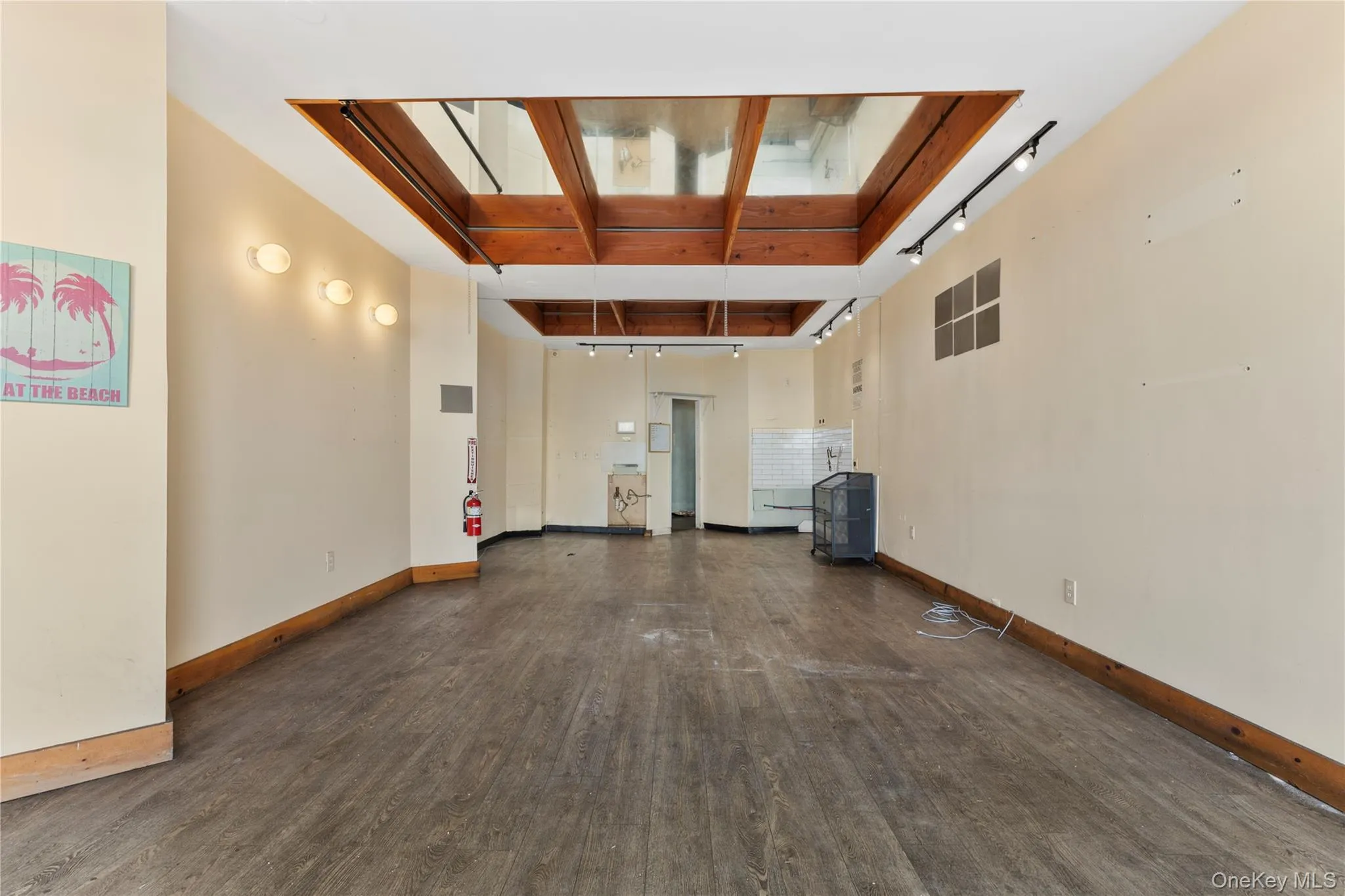 Spare room featuring track lighting and dark wood-style floors Spare room featuring track lighting and dark wood-style floors