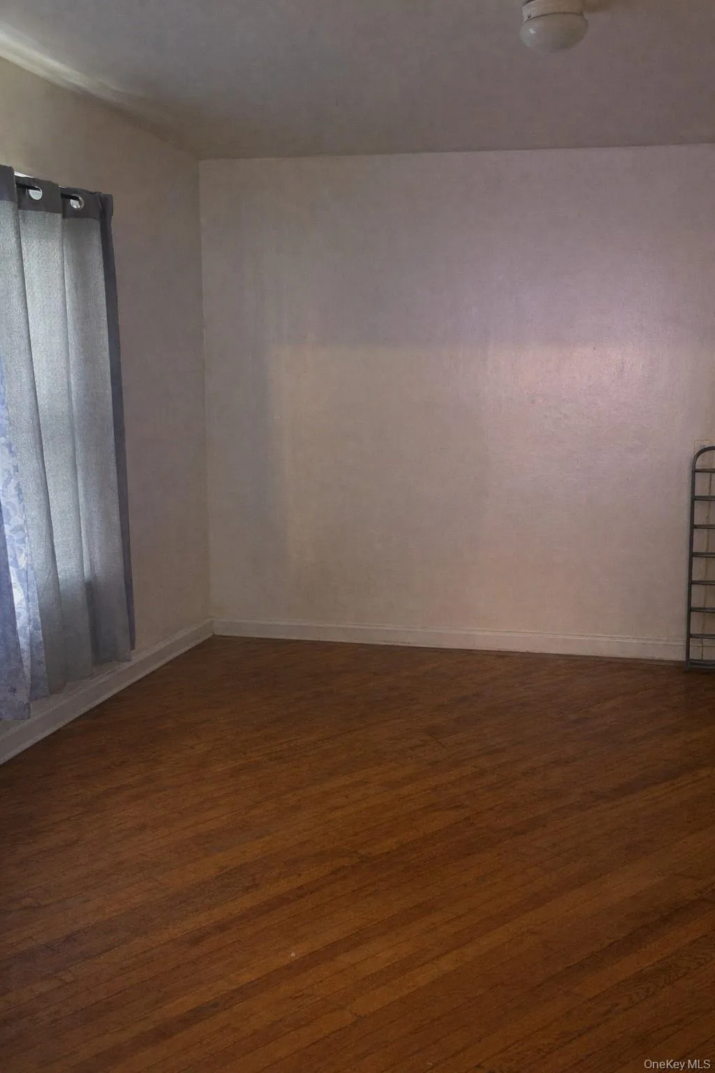 Unfurnished room with baseboards and dark wood-type flooring Unfurnished room with baseboards and dark wood-type flooring