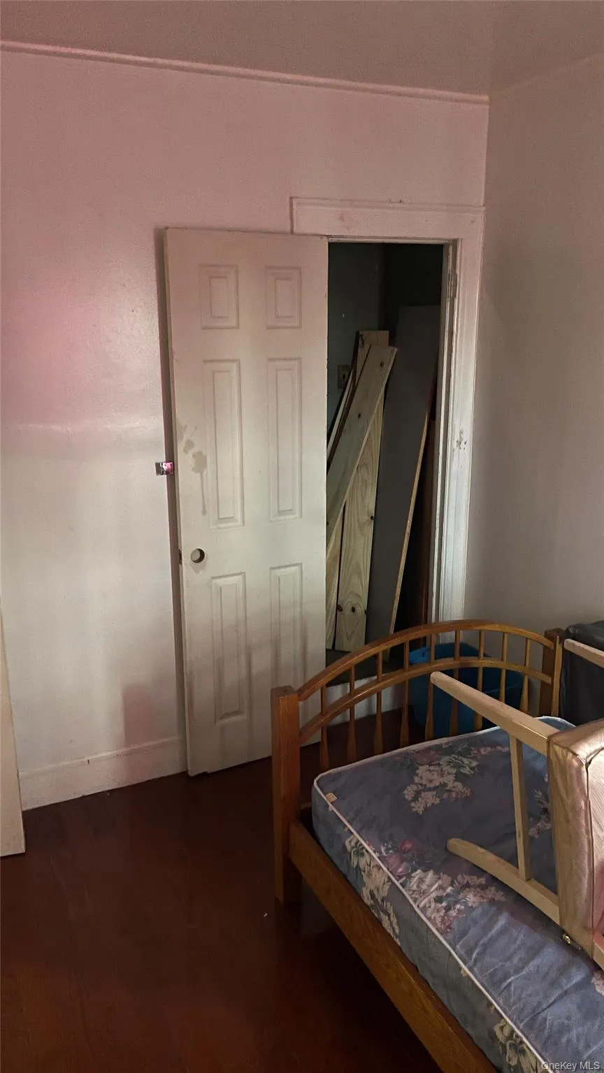 Bedroom with dark wood-type flooring and baseboards Bedroom with dark wood-type flooring and baseboards