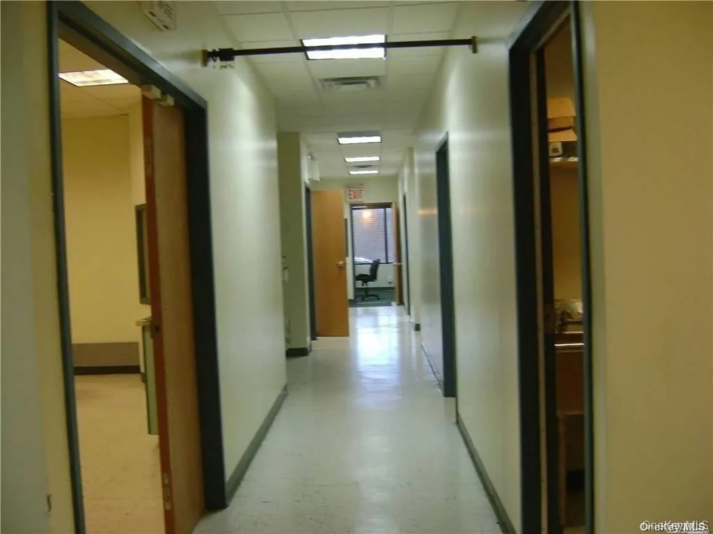 Hallway with light floors and a paneled ceiling Hallway with light floors and a paneled ceiling