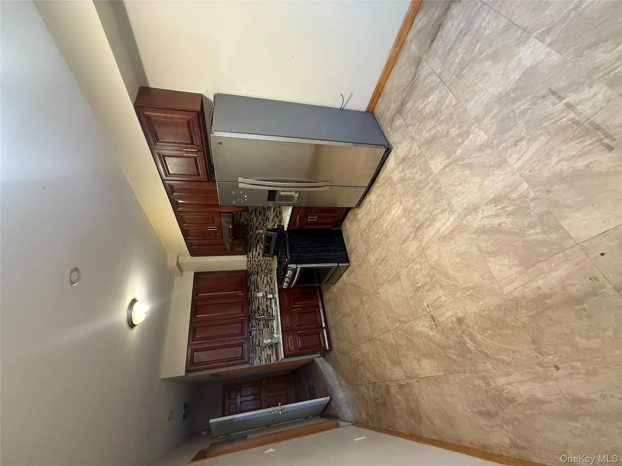 Kitchen with refrigerator, light countertops, gas stove, backsplash, and exhaust hood Kitchen with refrigerator, light countertops, gas stove, backsplash, and exhaust hood