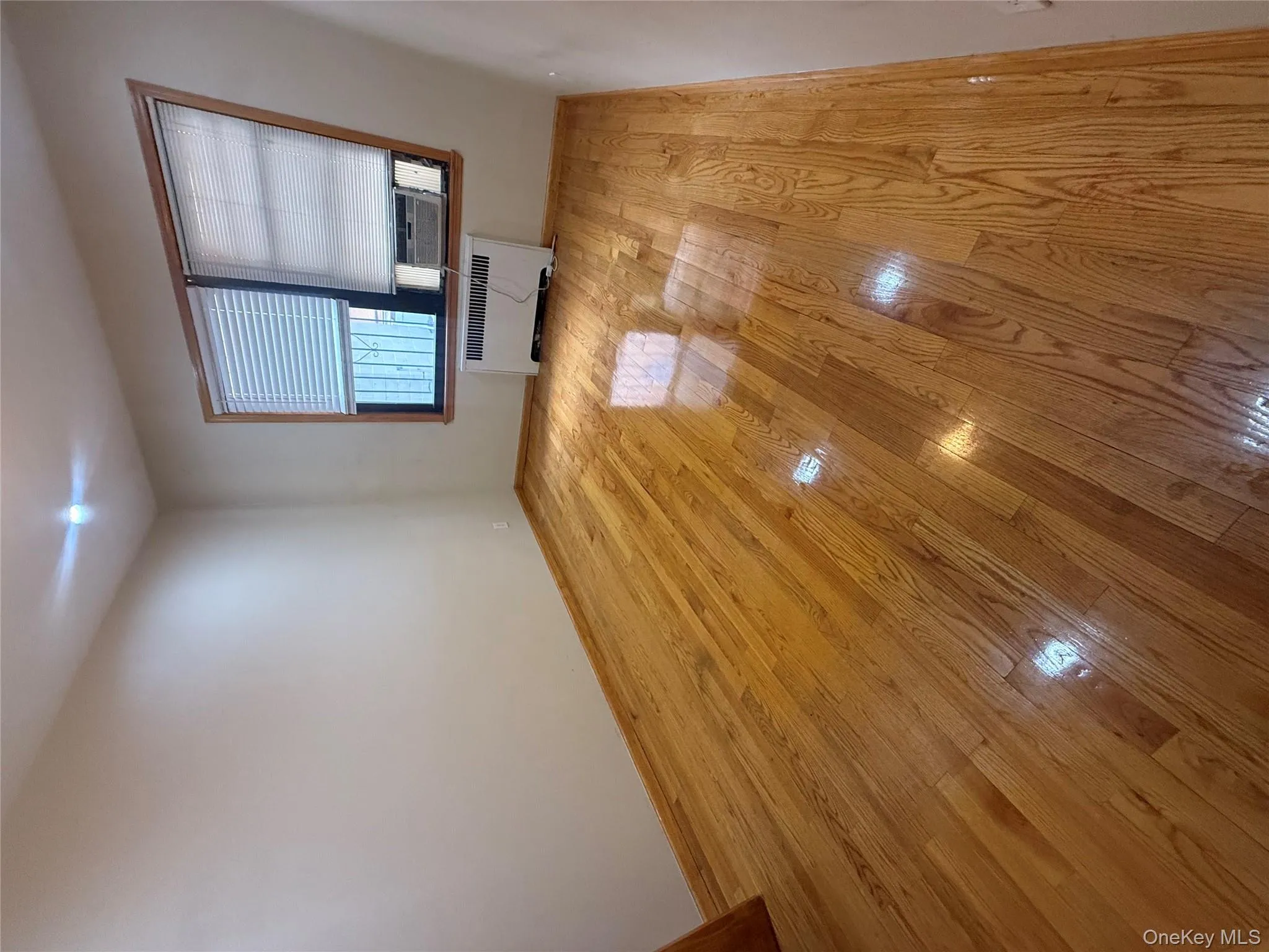 Spare room with radiator heating unit and light wood finished floors Spare room with radiator heating unit and light wood finished floors