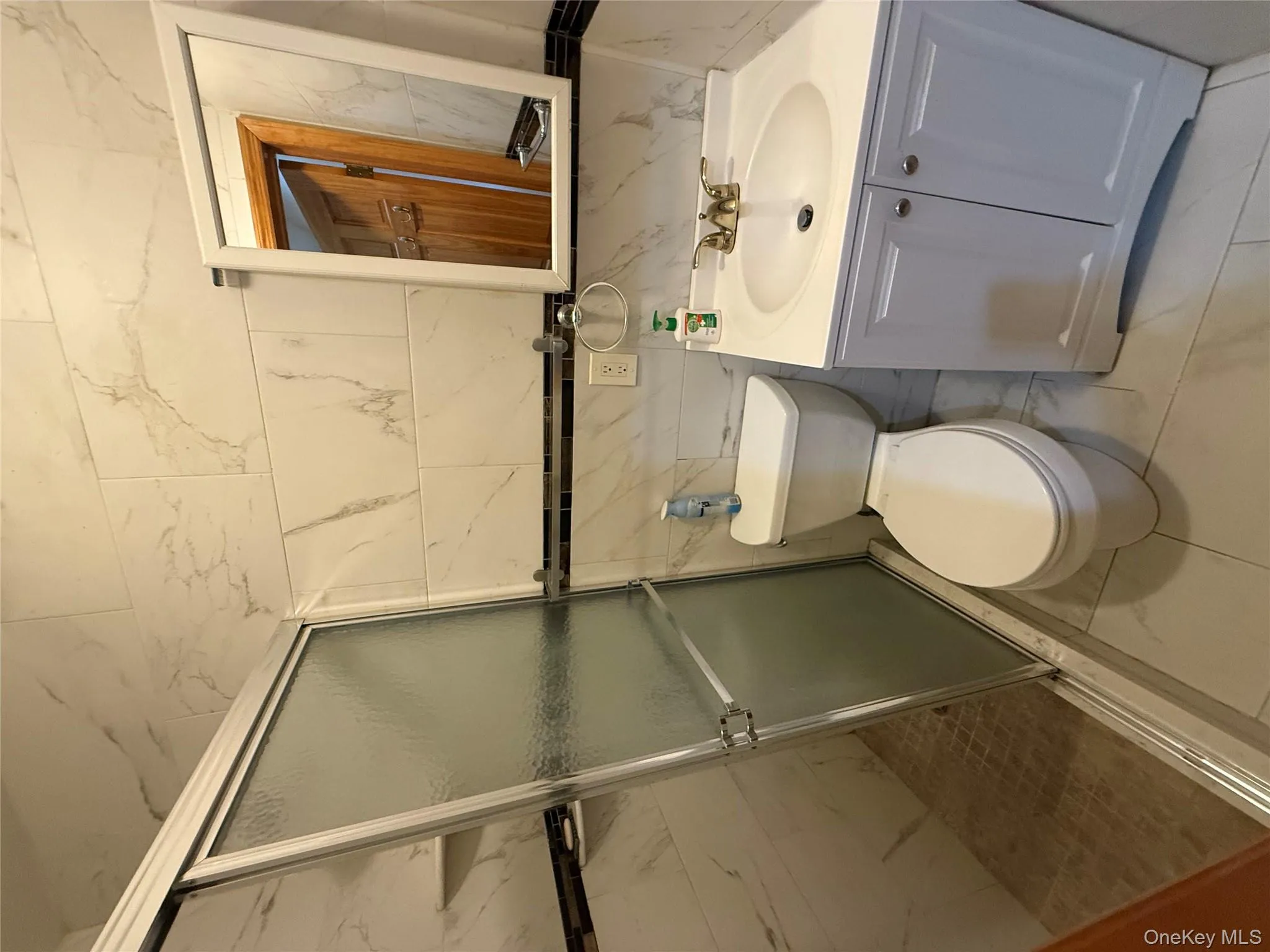 Full bath with vanity, tile walls, and a shower stall Full bath with vanity, tile walls, and a shower stall