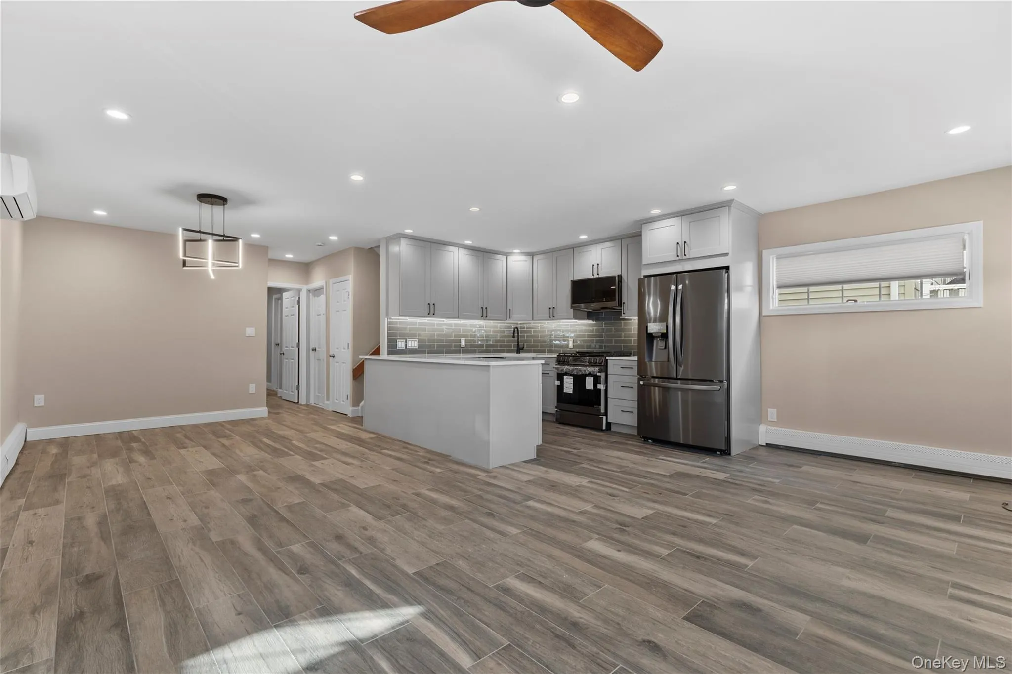 Kitchen featuring open floor plan, stainless steel appliances, recessed lighting, a peninsula, and backsplash Kitchen featuring open floor plan, stainless steel appliances, recessed lighting, a peninsula, and backsplash