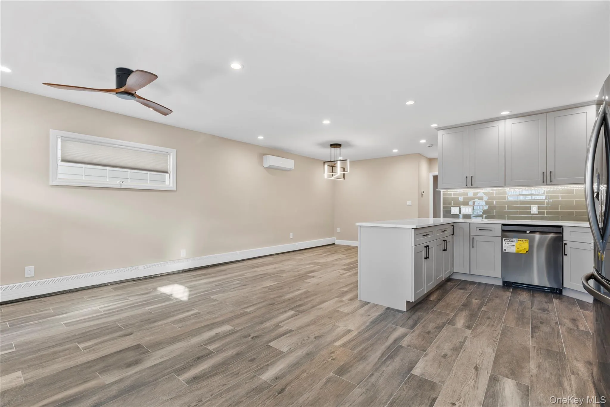 Kitchen with a peninsula, hanging light fixtures, wood tiled floors, appliances with stainless steel finishes, and recessed lighting Kitchen with a peninsula, hanging light fixtures, wood tiled floors, appliances with stainless steel finishes, and recessed lighting