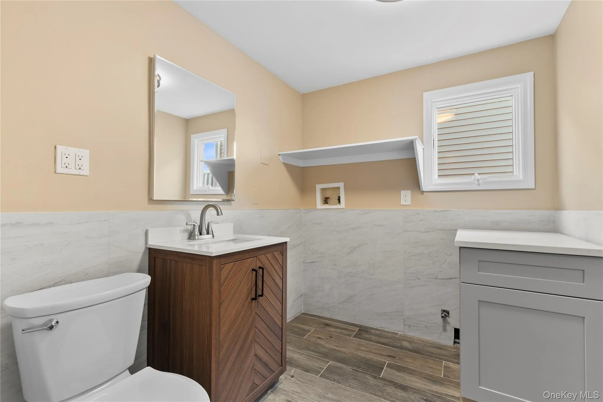 Bathroom with wainscoting, vanity, tile walls, and wood tiled floors Bathroom with wainscoting, vanity, tile walls, and wood tiled floors