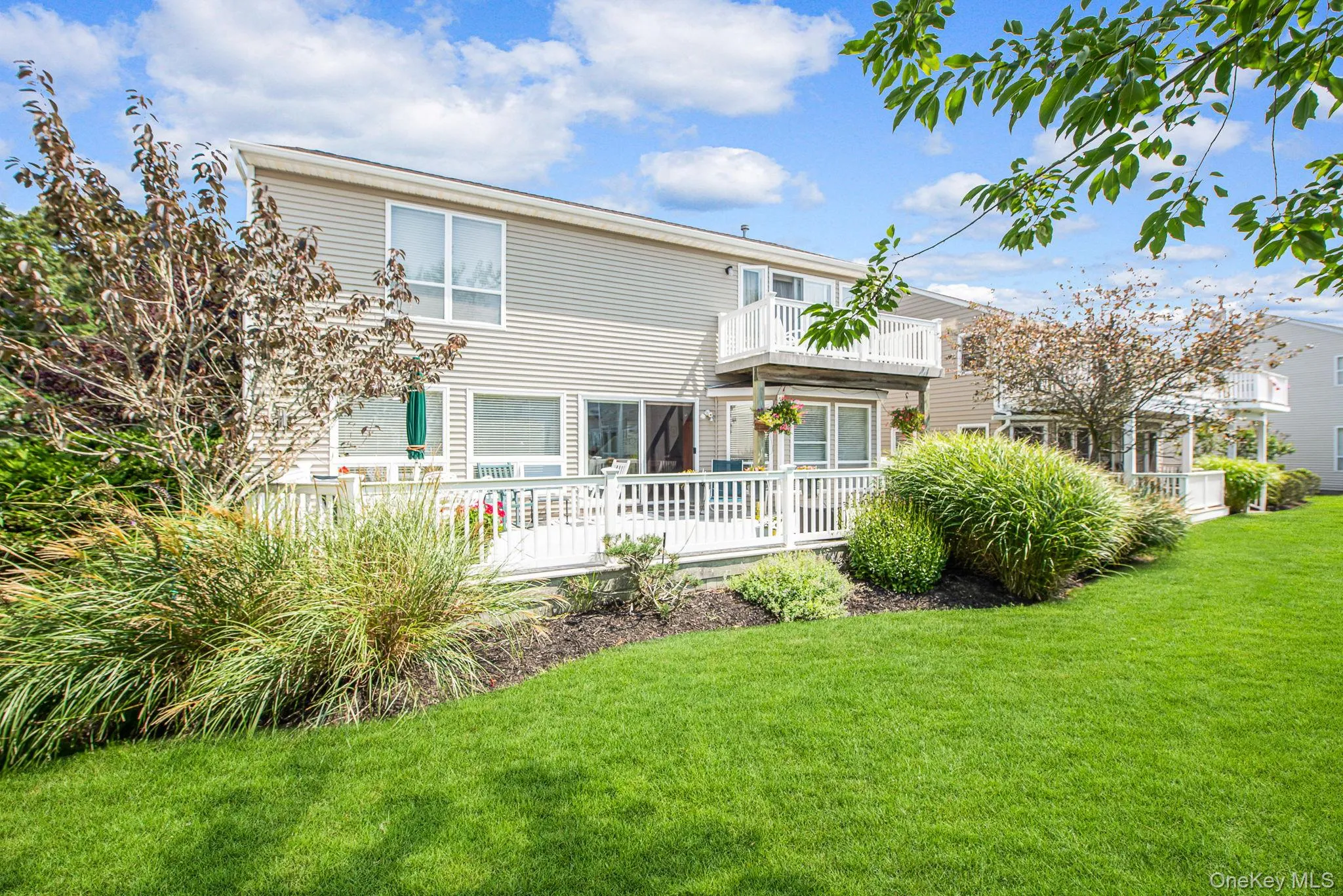 Back of property featuring a yard and a balcony Back of property featuring a yard and a balcony