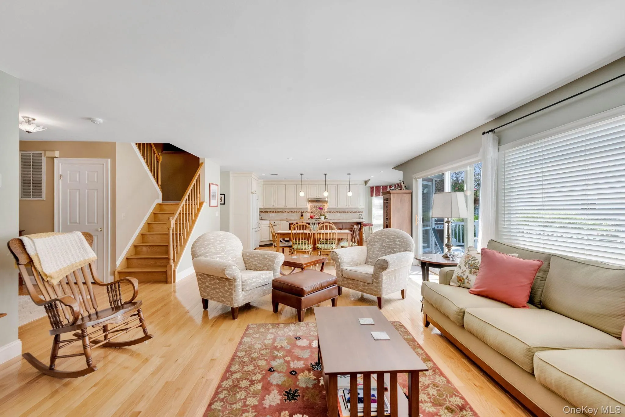 Living room featuring stairs and light wood-style flooring Living room featuring stairs and light wood-style flooring