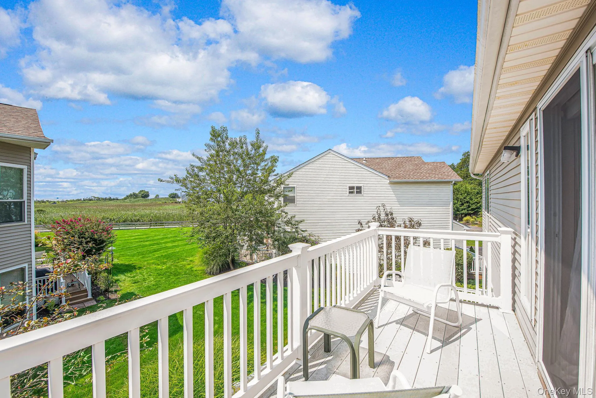 Wooden deck featuring a view of countryside, agricultural plots, and a lawn Wooden deck featuring a view of countryside, agricultural plots, and a lawn