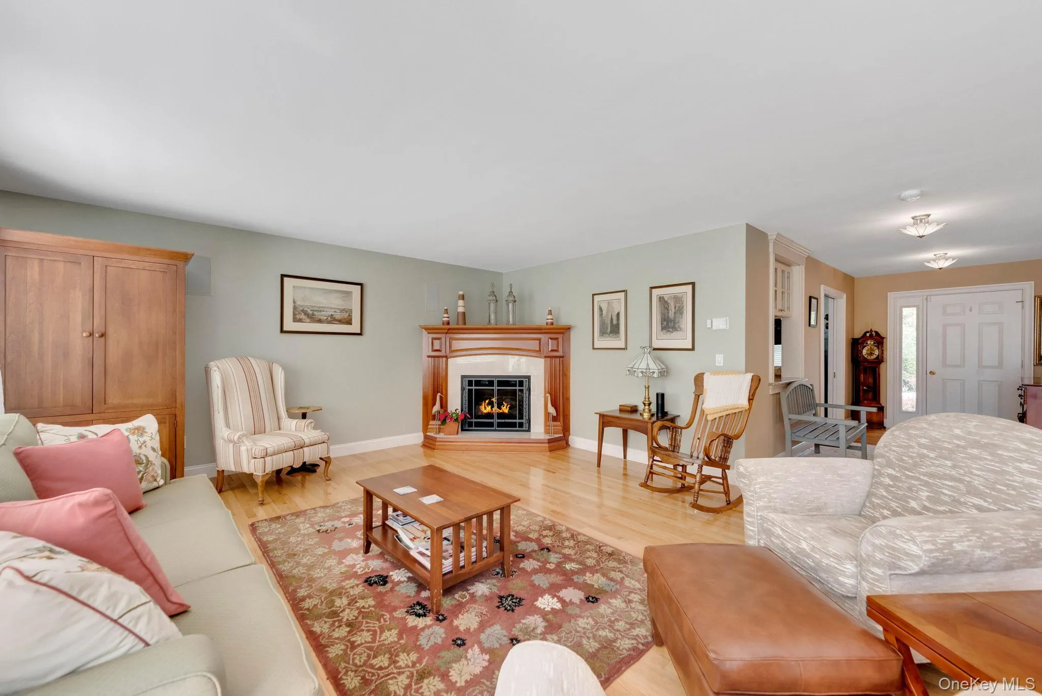 Living room with wood finished floors and a warm lit fireplace Living room with wood finished floors and a warm lit fireplace