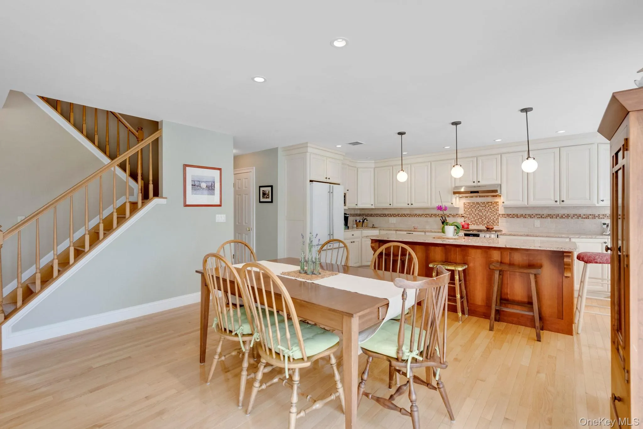 Dining area with stairway, light wood-style floors, and recessed lighting Dining area with stairway, light wood-style floors, and recessed lighting