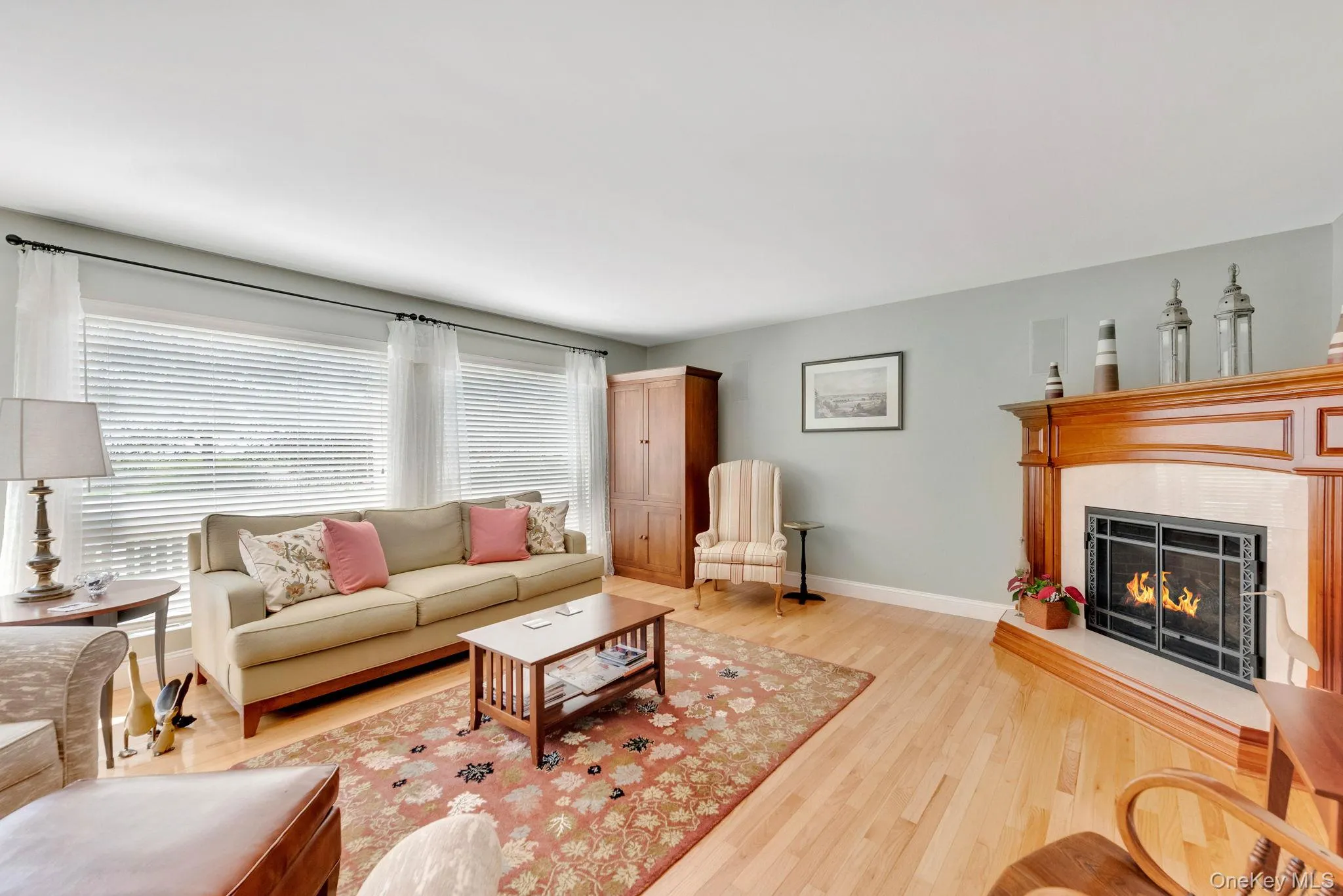 Living area featuring a lit fireplace and light wood-style floors Living area featuring a lit fireplace and light wood-style floors