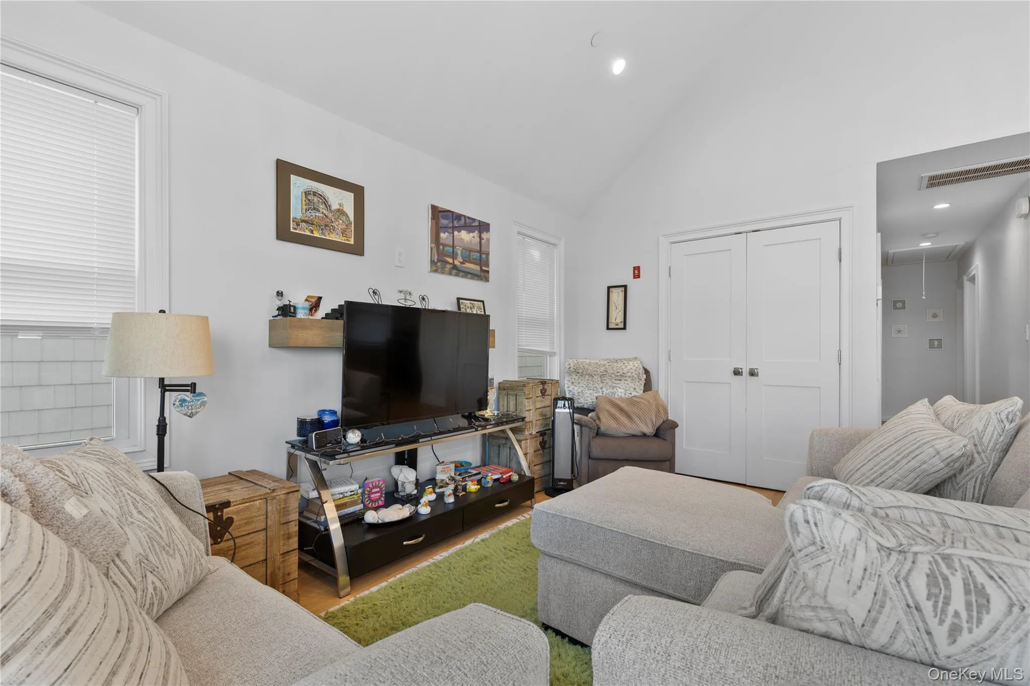 Living area with high vaulted ceiling, recessed lighting, wood finished floors, and attic access Living area with high vaulted ceiling, recessed lighting, wood finished floors, and attic access