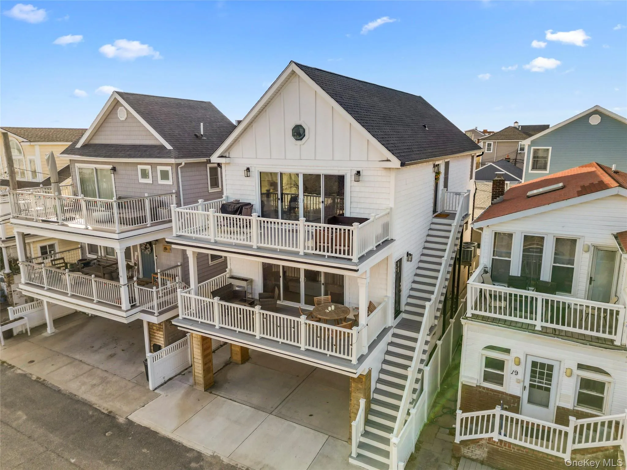 Rear view of property with board and batten siding, roof with shingles, and stairway Rear view of property with board and batten siding, roof with shingles, and stairway
