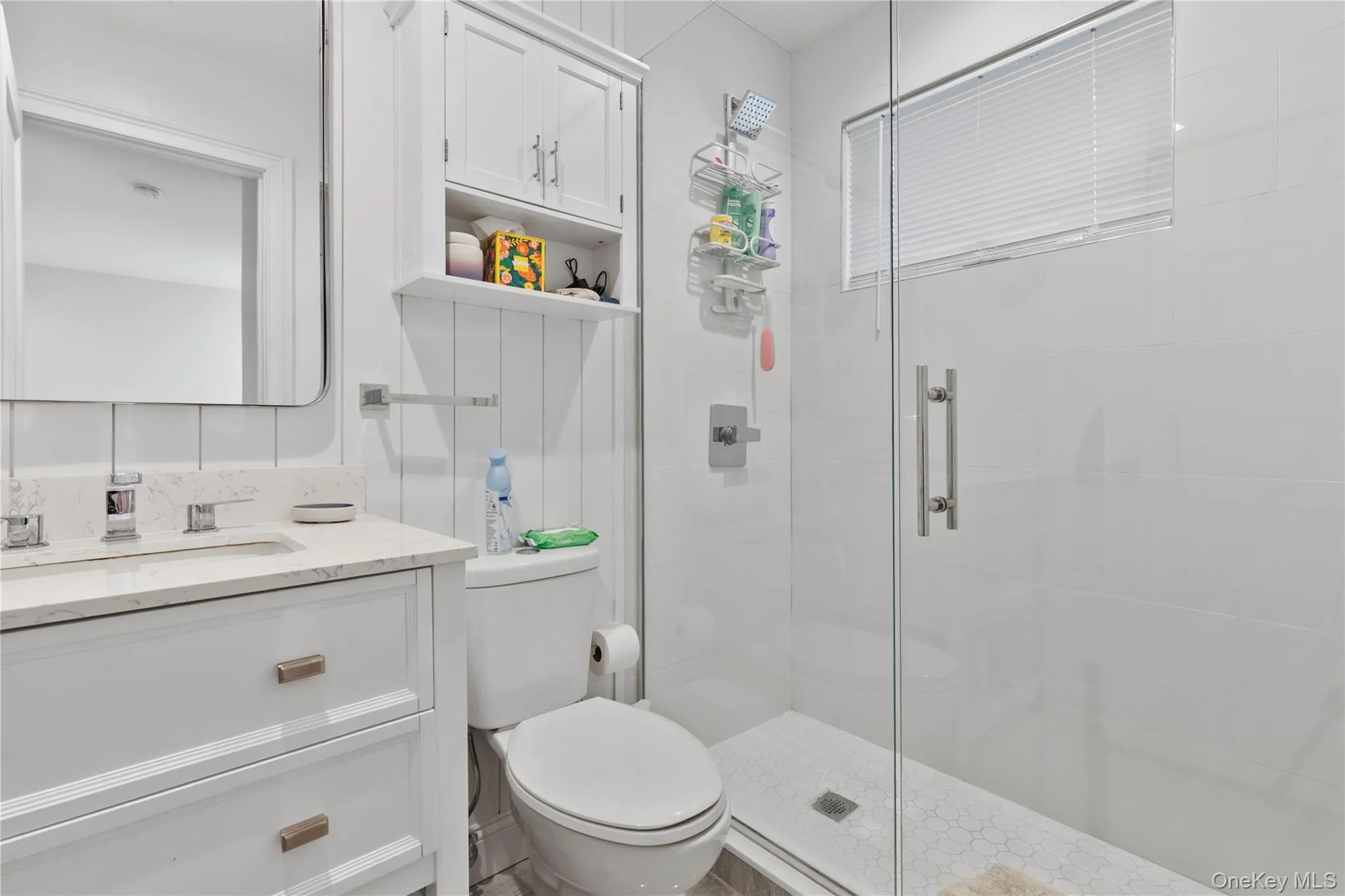 Bathroom featuring a shower stall and vanity Bathroom featuring a shower stall and vanity